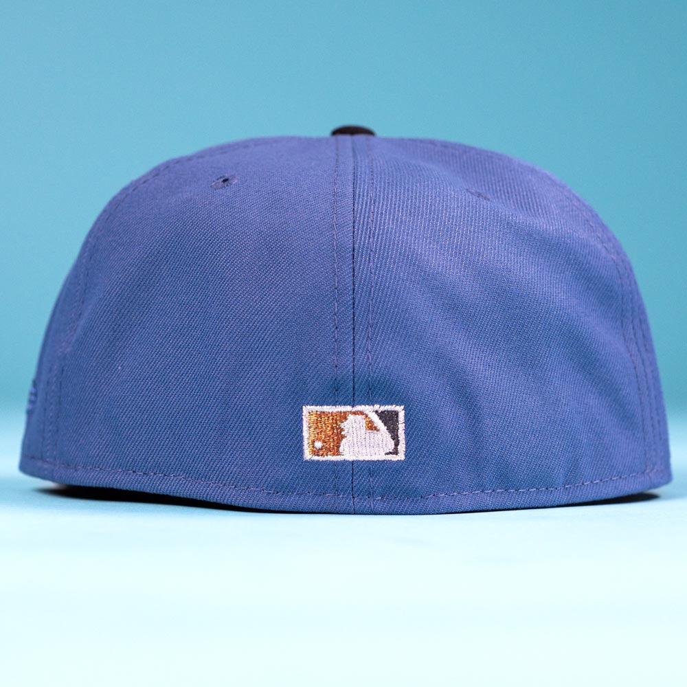 The Harbor Mark Canvas Houston Astros New Era 5950 Fitted Hat is displayed from the back, showing a white and gold MLB logo patch above the edge, set against a light blue background.