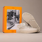 The VN000D9Z2N1 Atiba Oatmeal Suede Skate Wafflecup Half Cab Vans Shoes are shown in front of an orange Vans box with a black-and-white photo of a skateboarder on a handrail, featuring the classic Wafflecup sole.