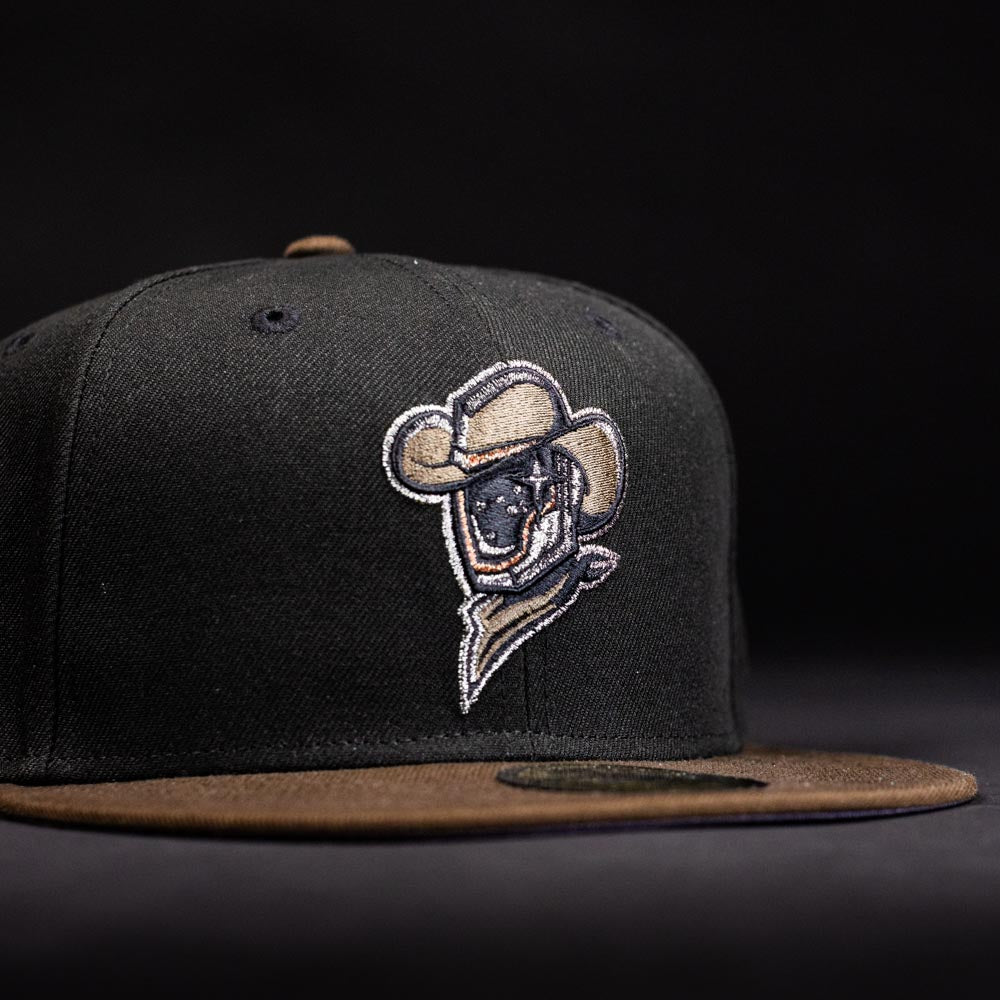 The Midnight Cowboy Sugarland Space Cowboys New Era 5950 Fitted Hat is black with a brown brim and features an embroidered cowboy logo in a hat and scarf on the front, set against a dark background.