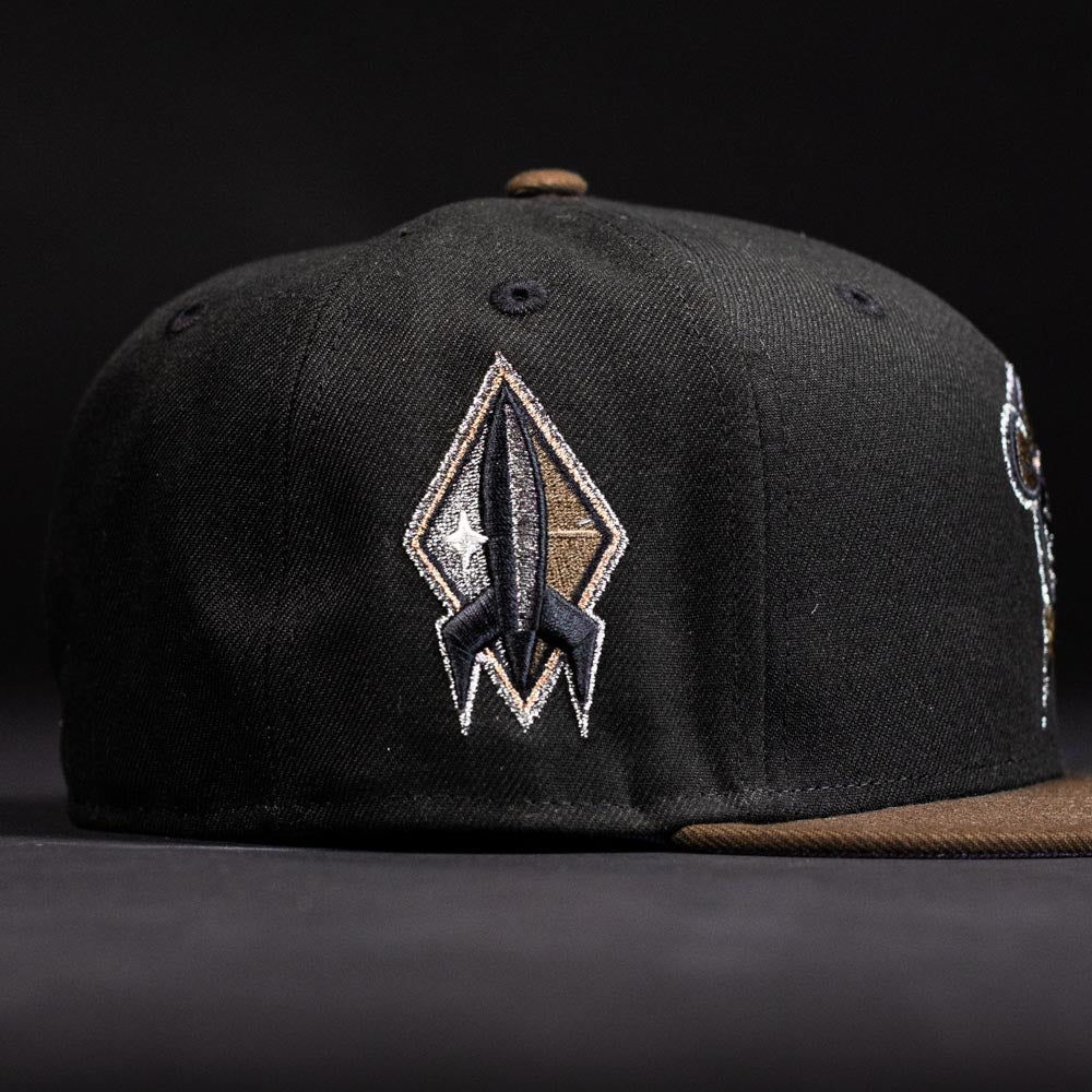 The Midnight Cowboy Sugarland Space Cowboys New Era Hat 5950 Fitted is a black cap with an embroidered rocket ship patch—an ideal accessory for Space Cowboys.