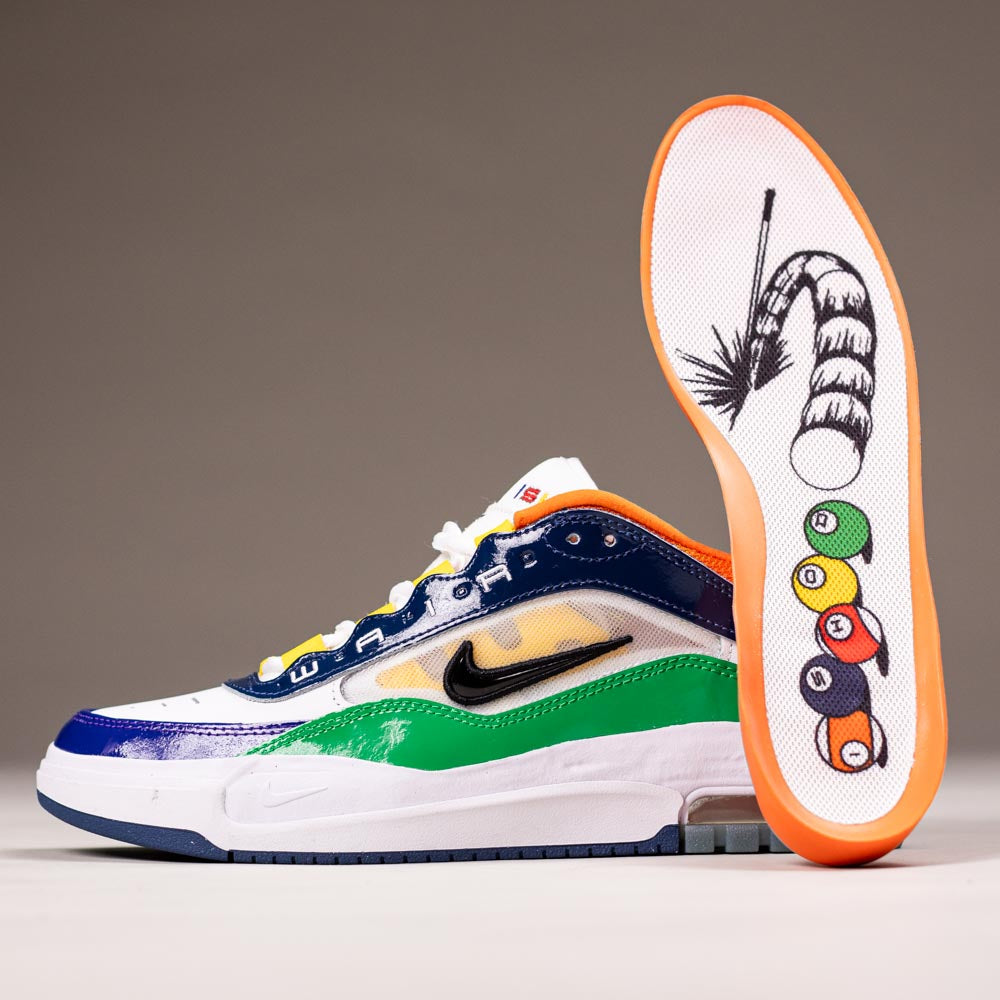 The HV1670600 University Red Black Amarillo Navy Air MAX Ishod Nike SB Suede Leather Skateboarding Shoe features vibrant blue, green, yellow, and orange accents, and its sole displays a cue stick hitting pool balls with Max Air cushioning.