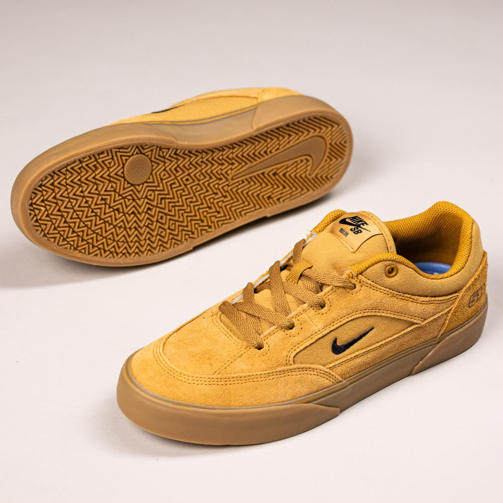 A pair of Nike SB Malor TE shoes (model HF3066701) in wheat gum/light brown/black/white—one upright showing side and top views, the other flipped to display the skate-specific tread pattern.