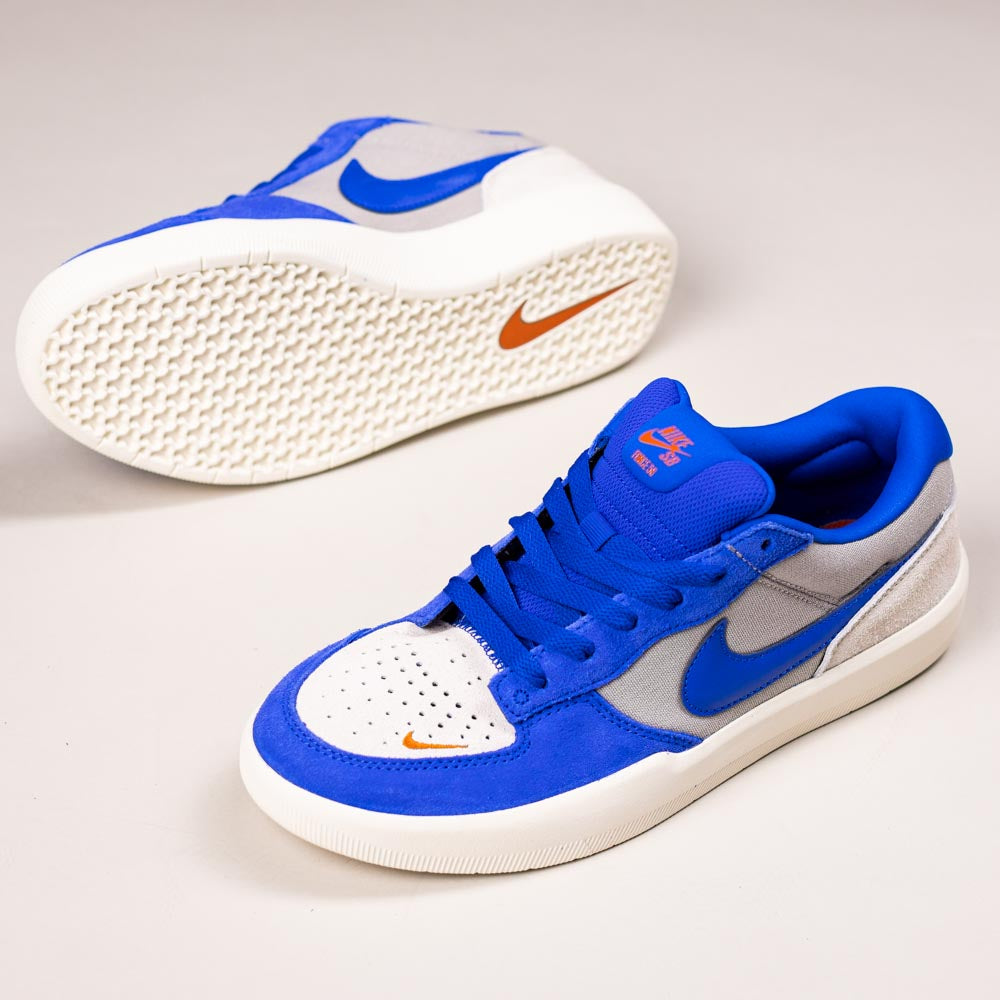 A pair of Nike SB Force 58 Suede Skateboarding Shoes (DV5477-011) in College Grey, Racer Blue, and Light Orewood with orange Swoosh, blue laces, and a textured white sole—fusing basketball heritage with cupsole skate design.