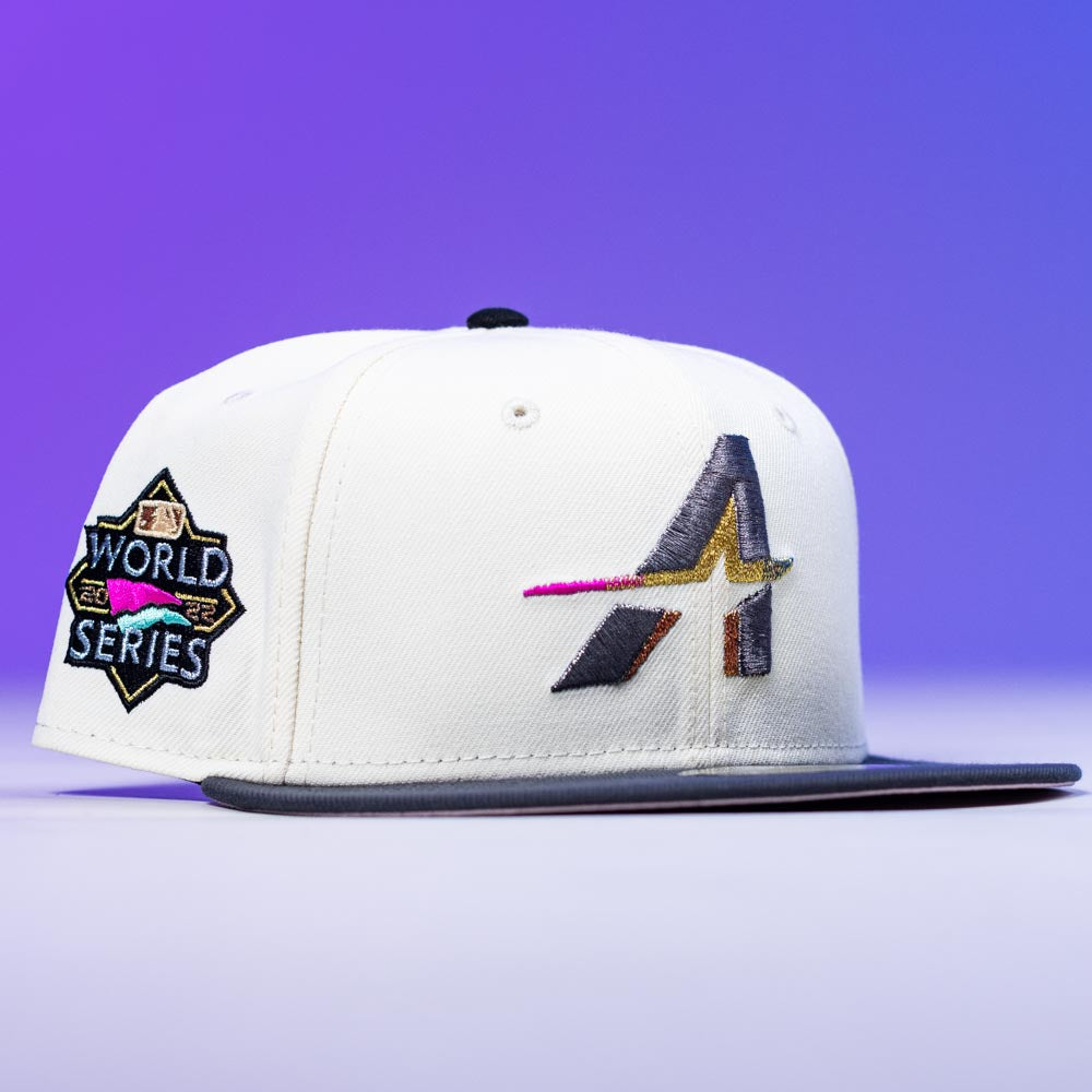 A Trilltiberi Rushmore WS22 Chrome Graphite Houston Astros New Era 5950 Fitted Hat, featuring a white crown, black brim, colorful A logo, and a black & gold World Series patch. Blue and purple gradient background.