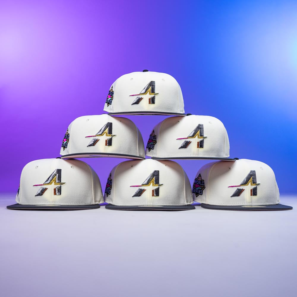 Six Noho Rushmore WS22 Chrome Graphite Houston Astros New Era Hat 5950 Fitted caps with stylized A logos and vibrant patches are stacked in a pyramid on a purple-blue gradient background, ideal for Astros fans.