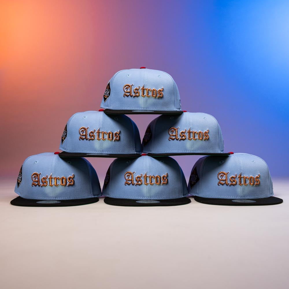 Six Sicko Mode Rushmore 2017 B Blue Black Houston Astros New Era 5950 Fitted hats are stacked in a pyramid. They feature gold embroidery, black brims, side patches, and are set against an orange and blue gradient backdrop.