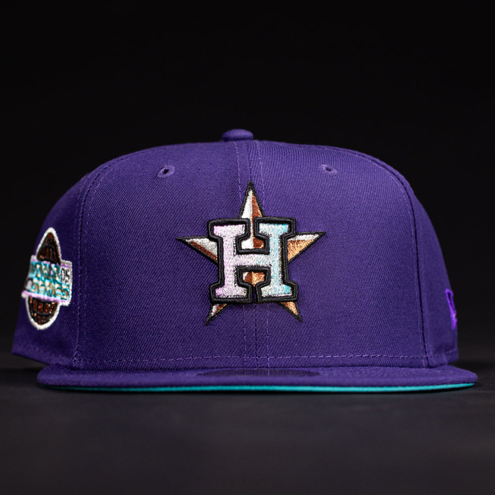 The DAY N HOU Rushmore WS05 Purple Teal Houston Astros New Era 5950 Fitted Hat features a large embroidered H over a star on the front and side patches, shown against a black background.