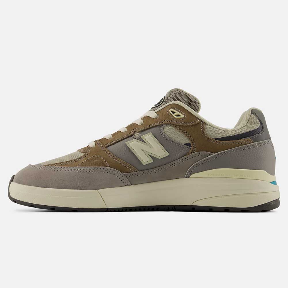 Side view of the 933 GRY Andrew Reynolds Gray Day New Balance Numeric skateboarding shoes in gray suede with mesh panels, cream sole, and iconic N logo—offering premium cushioning and blending comfort with heritage style.