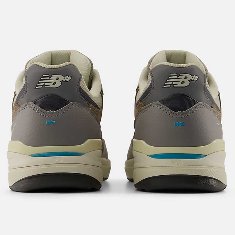 Rear view of the 933 GRY Andrew Reynolds Gray Day New Balance Numeric suede skateboarding shoes in gray with beige and blue accents, heritage details, “NB” heel logos, and chunky off-white soles.