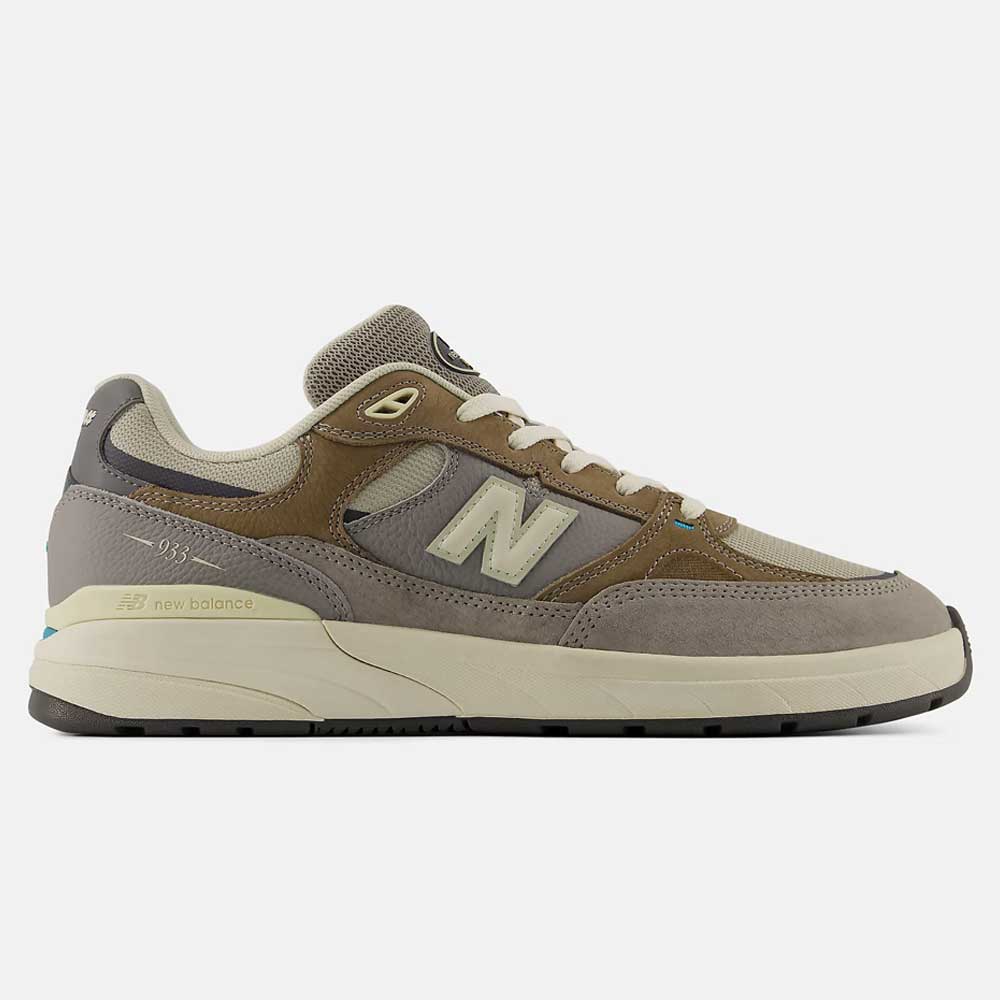 The 933 GRY Andrew Reynolds Gray Day New Balance Numeric Suede Skateboarding Shoes feature a brown, grey, and beige suede and mesh upper, premium cushioning, cream midsole, black outsole, and a bold N logo for classic heritage style.