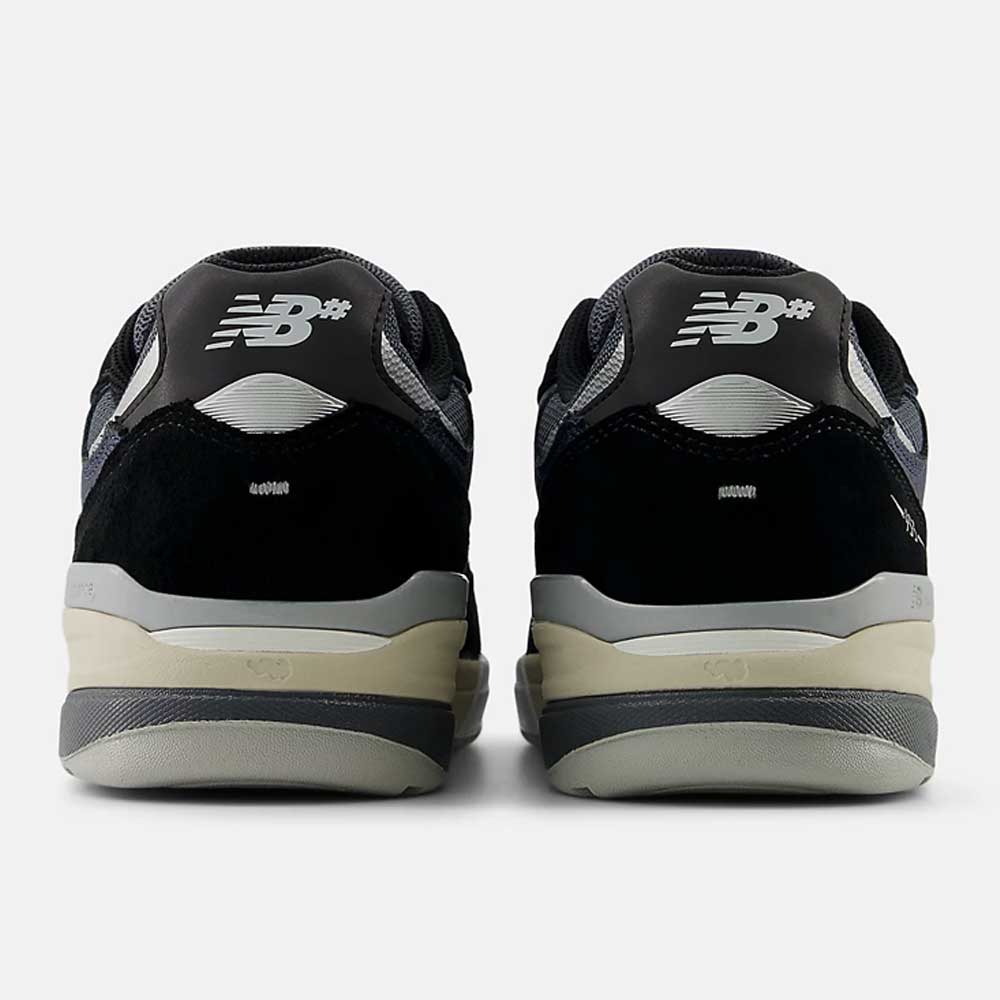 A pair of Black Eclipse 933 BNT Andrew Reynolds New Balance Numeric suede skateboarding shoes seen from the back, with a silver NB logo on black and gray heels, light gray soles, a beige midsole, and classic heritage design influences.