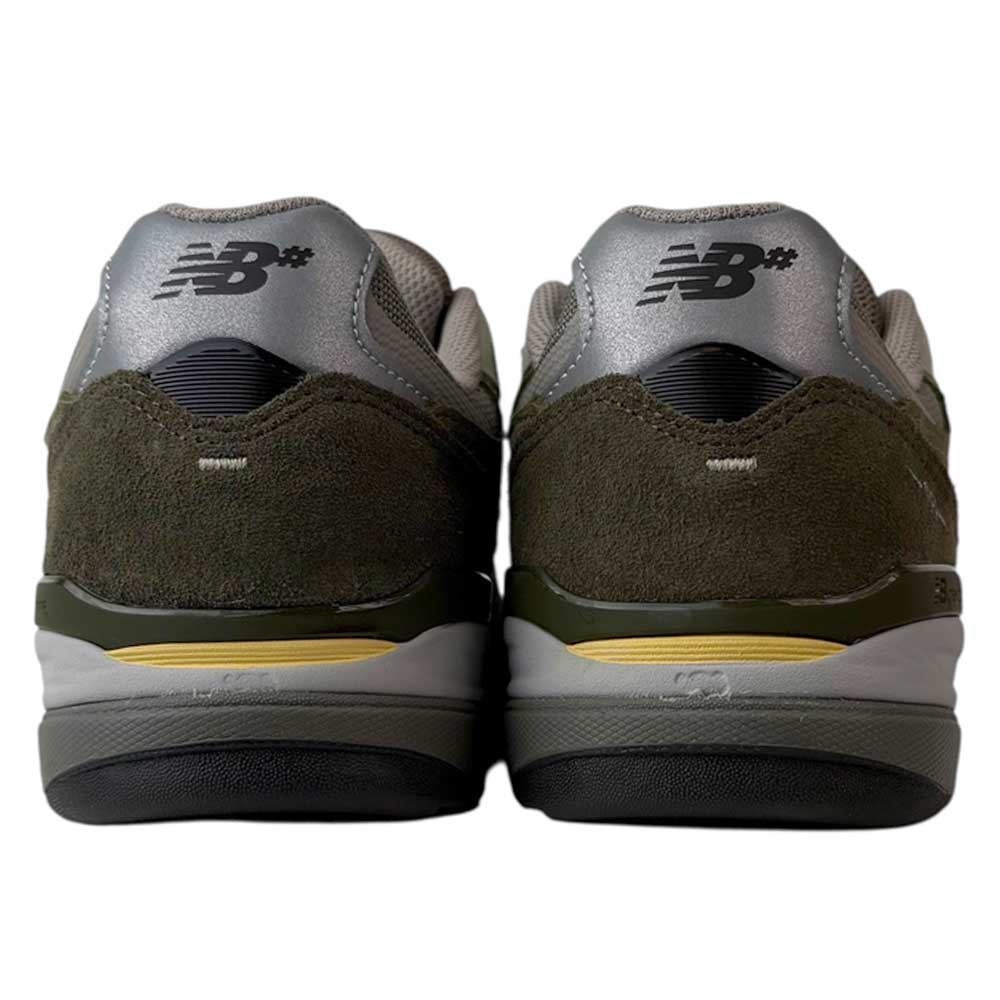 The 933 JKL Andrew Reynolds Grey Day New Balance Numeric Skateboarding Shoes feature olive suede uppers, light gray and silver accents, yellow midsole detailing, and black outsoles—combining style with durable skate performance.
