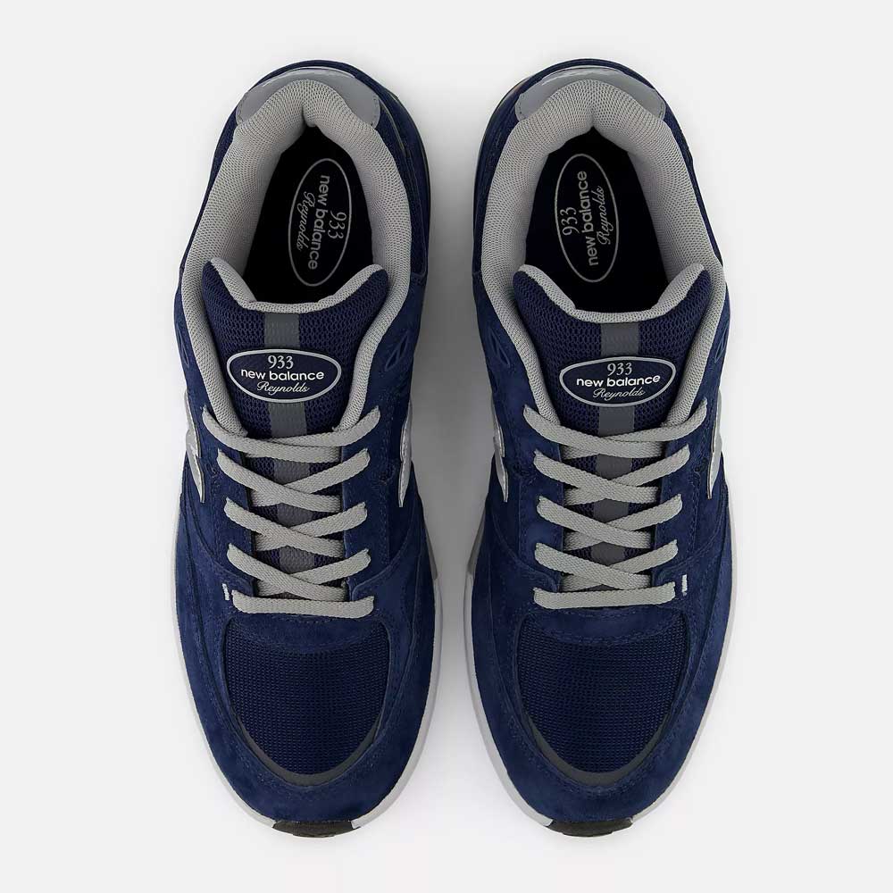 A pair of New Balance Numeric 933 LNV Navy Slate Gray Andrew Reynolds suede skateboarding shoes, featuring gray laces and trim and viewed from above on a white background, showcases a heritage-inspired design complemented by premium cushioning for all-day comfort.