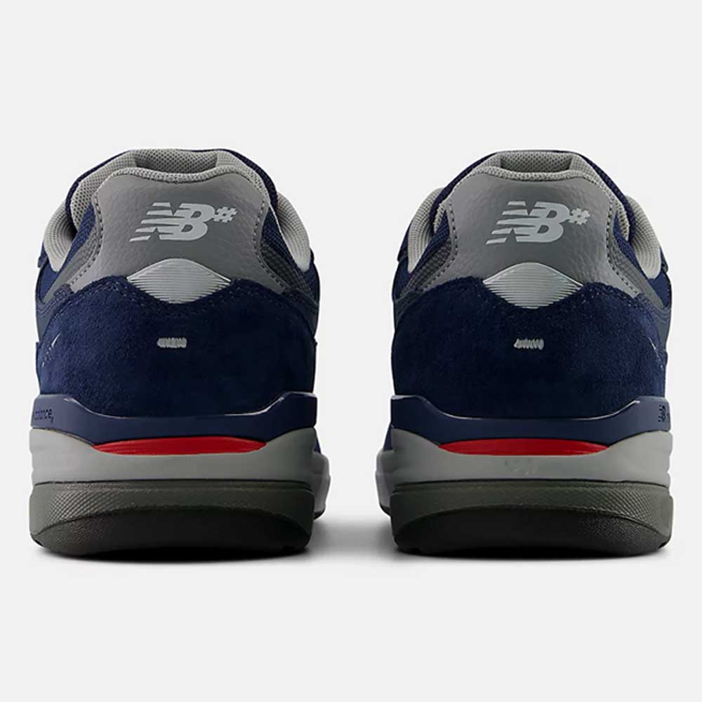 A pair of 933 LNV Navy Slate Gray Andrew Reynolds New Balance Numeric Suede Skateboarding Shoes in navy blue, gray, and red, viewed from the back with the NB logo displayed on the heels and a gray, red, and black rubber sole—these classic heritage sneakers blend timeless style with premium cushioning for all-day comfort.