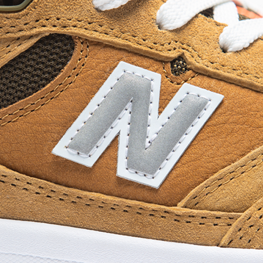 Close-up of the 933 MNO Andrew Reynolds Brown Grey New Balance Numeric skateboarding shoe in suede, featuring a white and gray “N” logo, white laces, and a white midsole.
