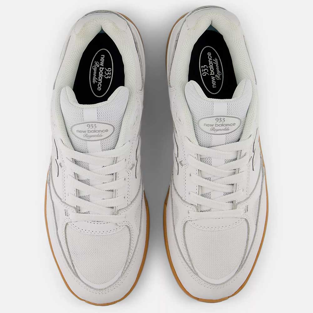 Top view of a pair of white and black New Balance Numeric 933 WWB Andrew Reynolds suede skateboarding shoes featuring mesh and suede details, white laces, tan rubber outsoles, and insoles displaying the New Balance logo and model.