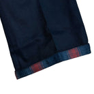 Close-up of the cuff on an A865SBLK Black Spitfire Flannel Cuffed Dickies Skateboarding Pant Regular Fit Twill, showing the folded hem and red and blue Spitfire flannel inner lining.