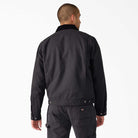 A person with short hair, seen from behind, is wearing the A8702 Black Blanket Lined Painter Canvas Jacket Dickies Skateboarding and matching black pants against a plain white background.