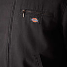 Close-up of the Dickies Skateboarding A8702 Black Blanket Lined Painter Canvas Jacket, featuring a zippered chest pocket and the Dickies logo tag above the pocket.