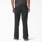 A person wearing A8768 Regular Fit Twill Pant Black Dickies Skateboarding and gray slip-on shoes, shown from the back against a plain white background.