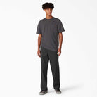 A young man stands facing forward against a white background, wearing a dark gray T-shirt, gray sneakers, and A8768 Regular Fit Twill Pant Black Dickies Skateboarding.