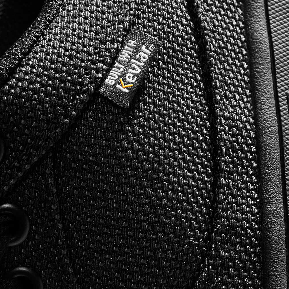 Close-up of the Accel Kevlar Black Es Shoes Skateboarding, showing black textured fabric with a "built with Kevlar" tag near the laces. Durable material and fine stitching make them ideal for skateboarding.