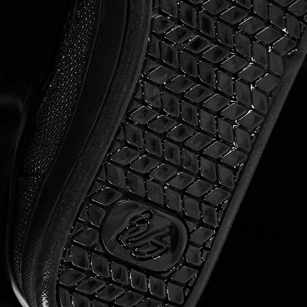 Close-up of the Accel Kevlar Black Es Shoes Skateboarding sole, showcasing a diamond-shaped tread for grip and a central circular logo—signature features that make this shoe iconic in skate culture.