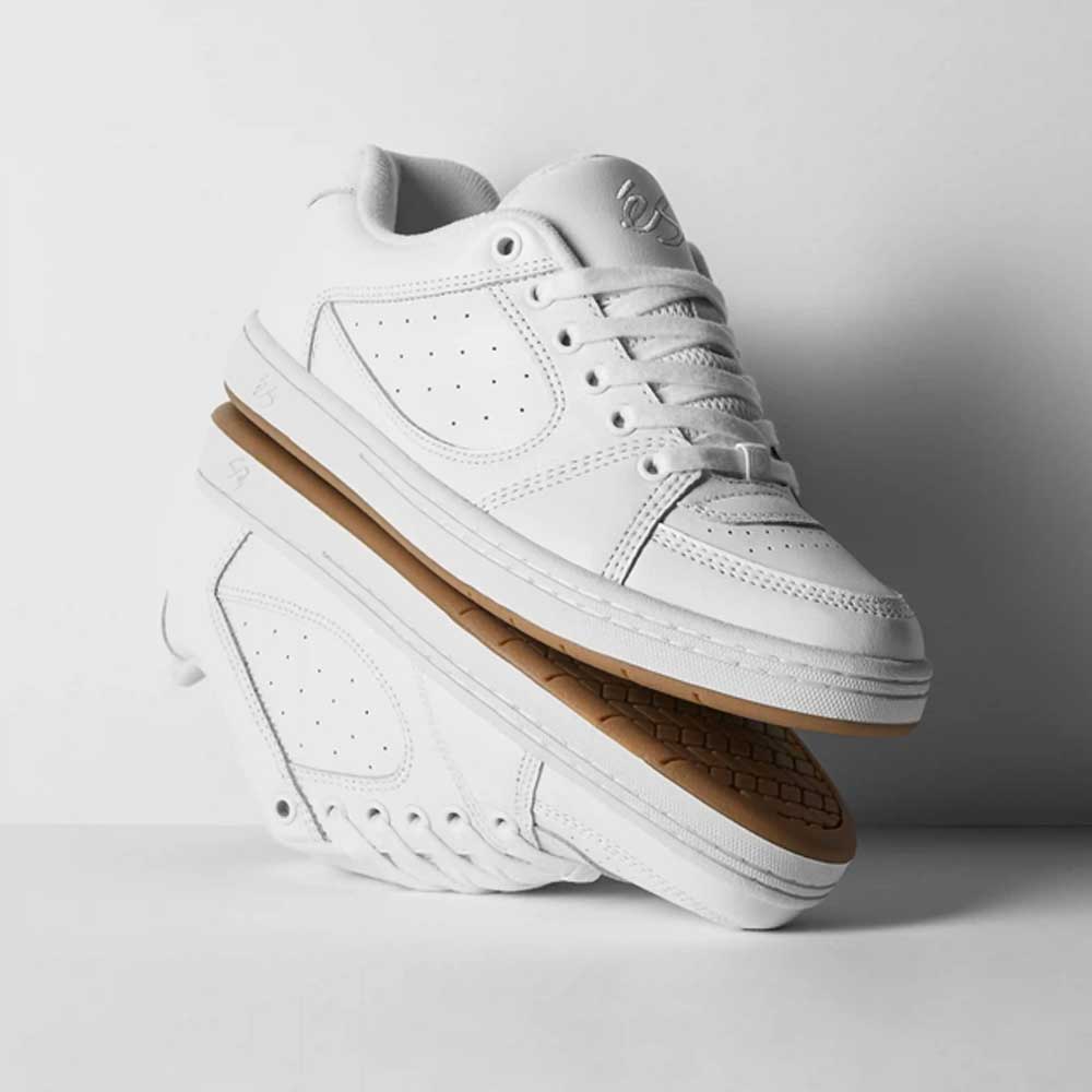 A pair of Accel White Leather Es Shoes Skateboarding with gum soles are stacked against a white background—one upright, the other sideways displaying the textured sole—ideal for those who love classic skate style.