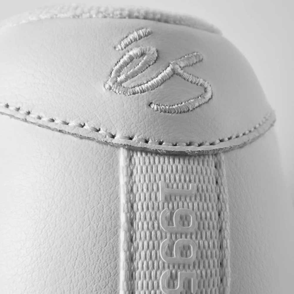 Close-up of the Accel White Leather Es Shoes Skateboarding heel, featuring stitched signature-style embroidery and '1995' embossed on a textured strip, inspired by the classic éS Accel design.