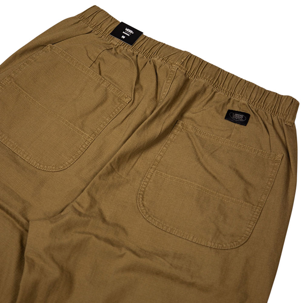Close-up of the back of the Vans Addison Barrel Olive Brown VN0010HYOVB pants, featuring an elastic waistband and two large square pockets. These olive brown pants are designed in a loose-fit denim style reminiscent of classic skate jeans, with a small Vans logo tag visible above the right pocket.