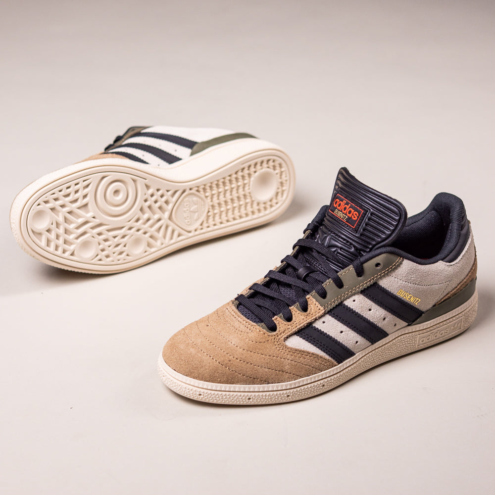 A pair of Busenitz Tan White Black HQ4746 Adidas Skateboarding Suede Shoes features a durable tan suede upper, grey and black accents, white midsoles, signature side stripes, and a textured sole.