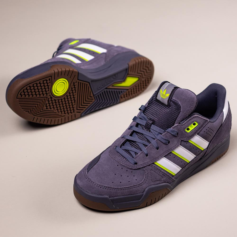 A pair of HQ4813 Gray White Green Tekkira Adidas skateboarding suede shoes: featuring a gray suede upper, white and green stripes, gum soles, and black accents. One shoe stands upright while the other lies on its side to display the textured sole.