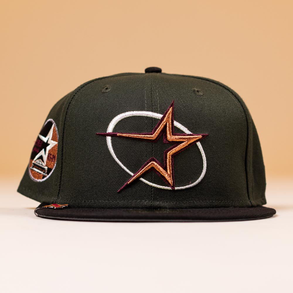 The GWOP Dark Green Burgundy Bronze Circle Star Houston Astros New Era 5950 Hat features a bold star logo on the front and a side star patch, shown against a beige background.