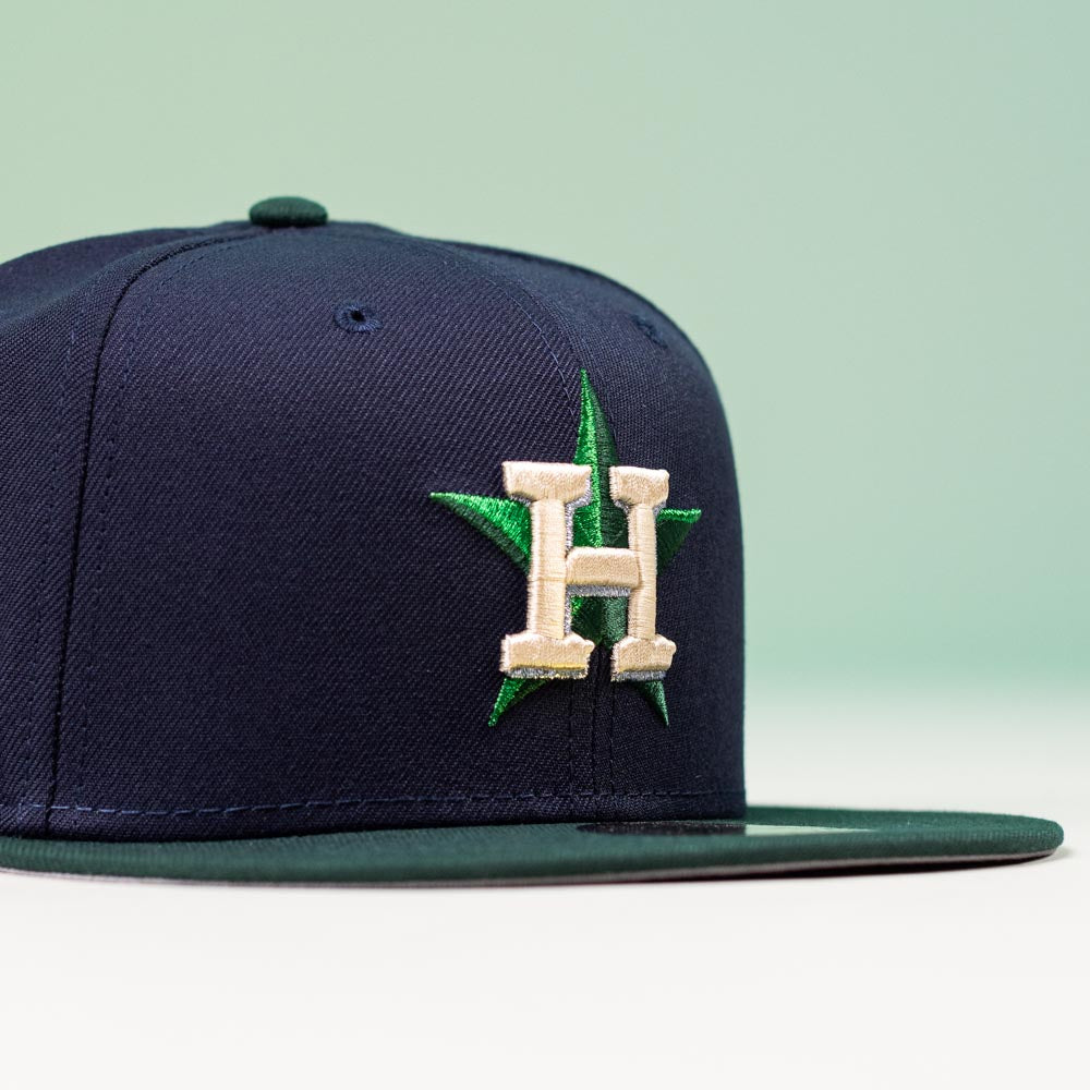 The Creator Pack Navy Green Houston Astros New Era Hat 5950 Fitted by New Era features a navy blue crown, green brim, and a gold H over a green star on the front—perfect for showing Astros pride in standout style.
