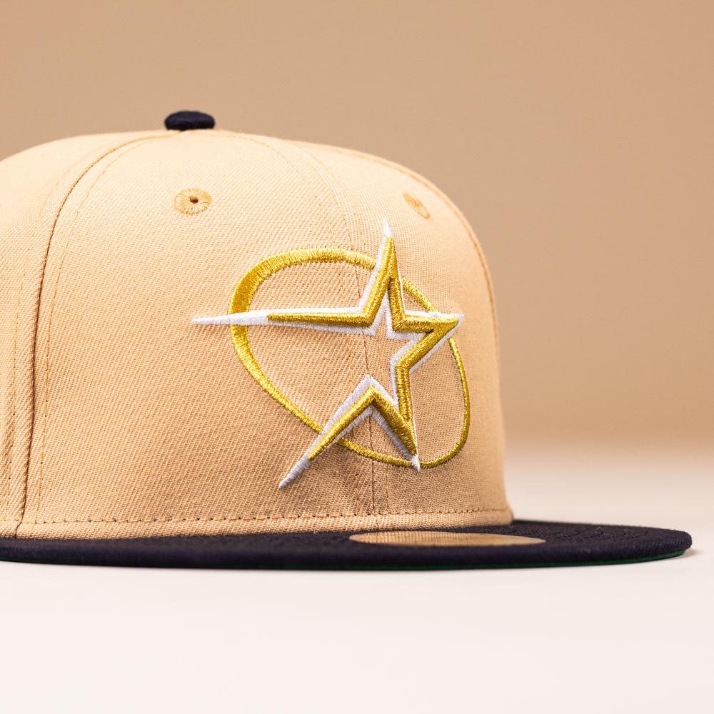 A tan New Era 5950 fitted Astros hat with a black brim and a bold yellow and white circle star logo on the front. Product: Tan Black Circle Star Houston Astros New Era Hat 5950 Fitted 5950 Day. Background is solid light beige.