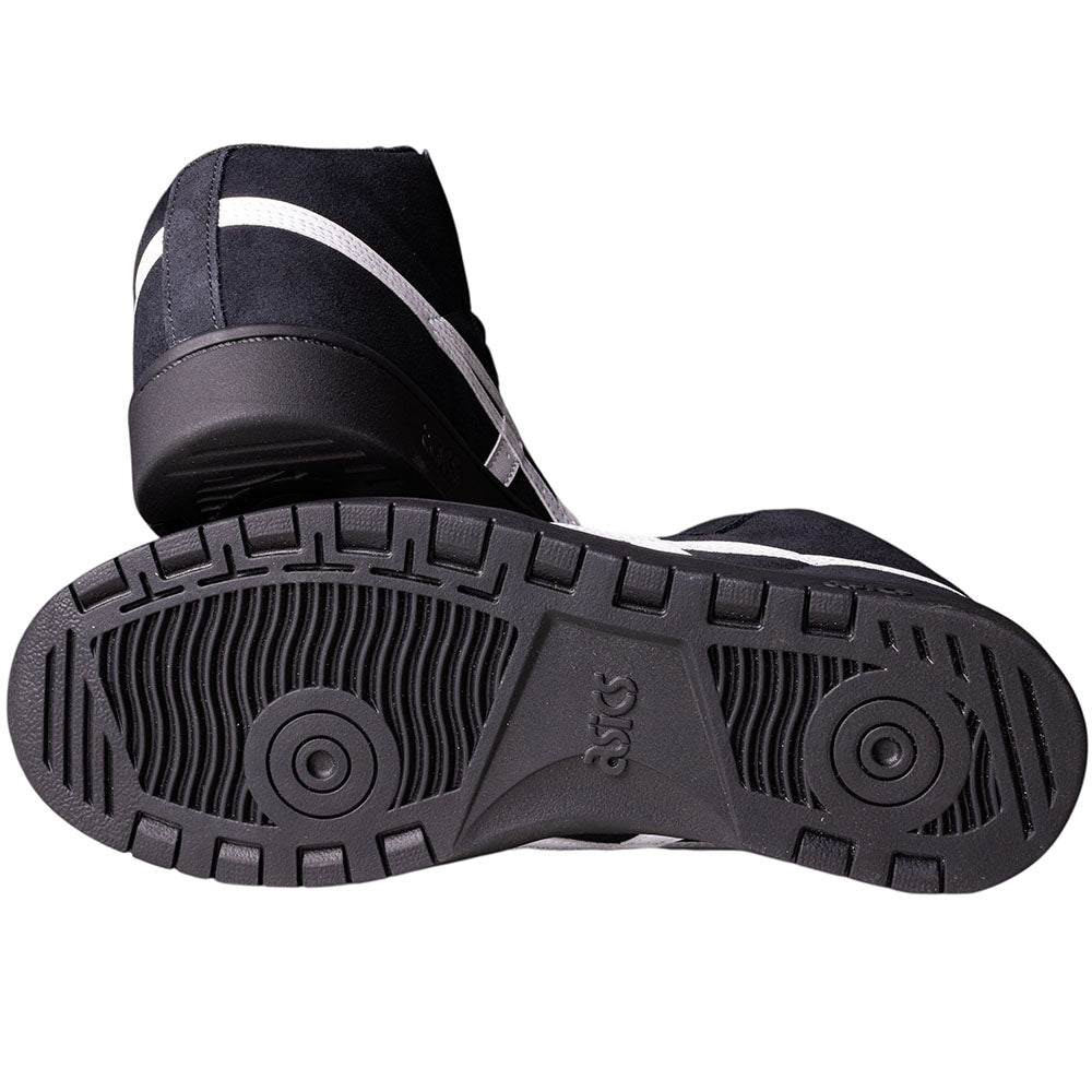 A pair of Japan Pro MT Asics Black Bright White 1201B003003 suede skateboarding shoes, with one shoe on its side and the other showing the textured tread and ASICS logo on the sole.