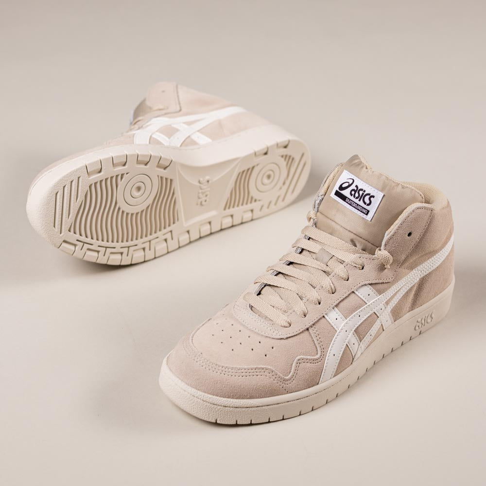 The Japan Pro MT Asics Feather Grey Cream 1201B033020 suede skateboarding shoes are featured, one upright and one on its side to showcase the durable sole and white side stripes.