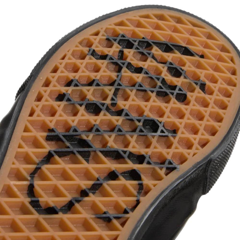 Close-up of a rubber gum-colored waffle-tread sole on a pair of Atiba Vans Skate Chukka Black Black VN0A7SLZBKA1 Suede Skateboarding Shoes, featuring a black graphic printed across the bottom.