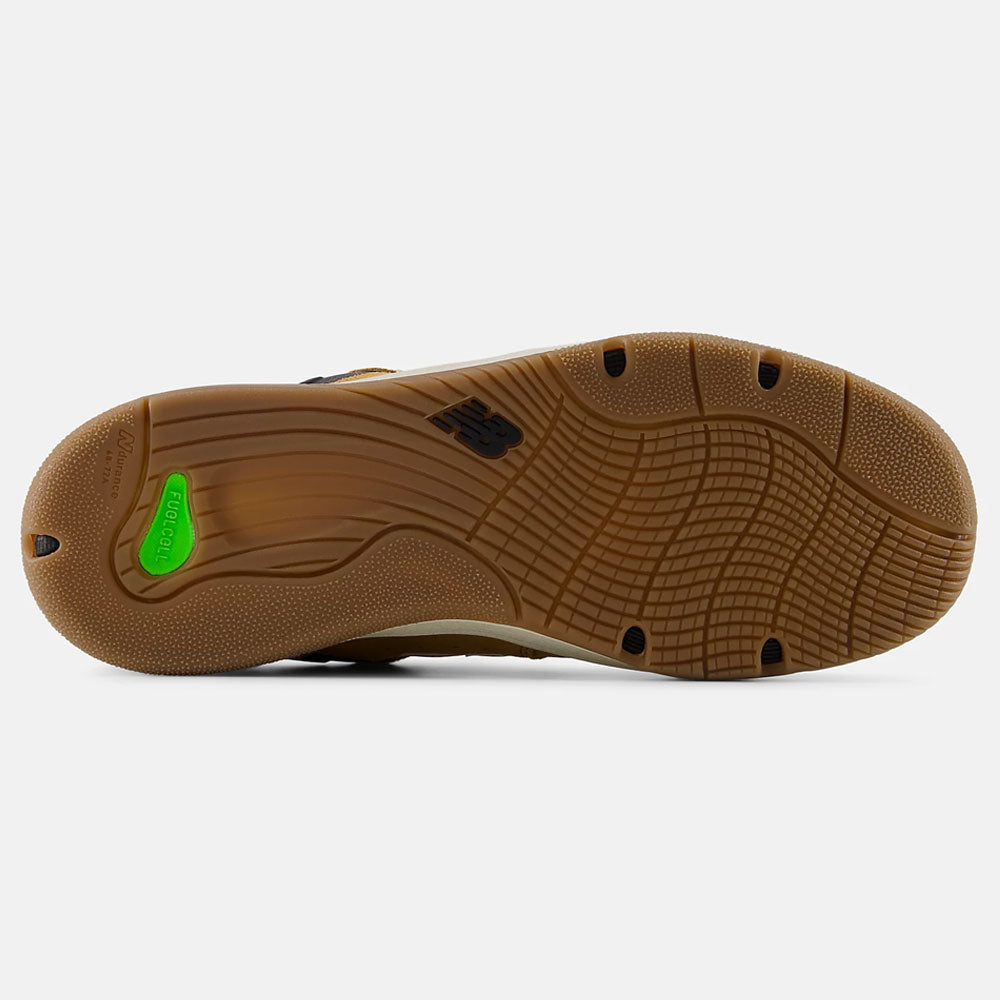 The image shows the bottom view of the Baked Clay Black 1010 LV New Balance Numeric suede skateboarding shoe sole with a wavy tread, black NB logo at the center, and a green accent near the heel.