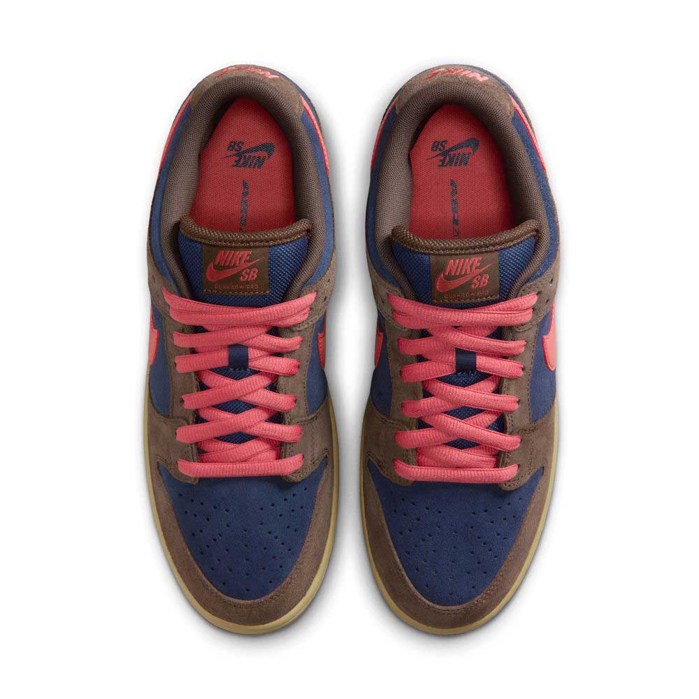 A pair of Baroque Brown Adobe Midnight Navy Dunk Low Pro HQ1625200 Nike SB suede shoes, shown from above with brown overlays, navy panels, bright pink laces, pink SB tongue logos, and a gum sole—a modern twist on classic style.