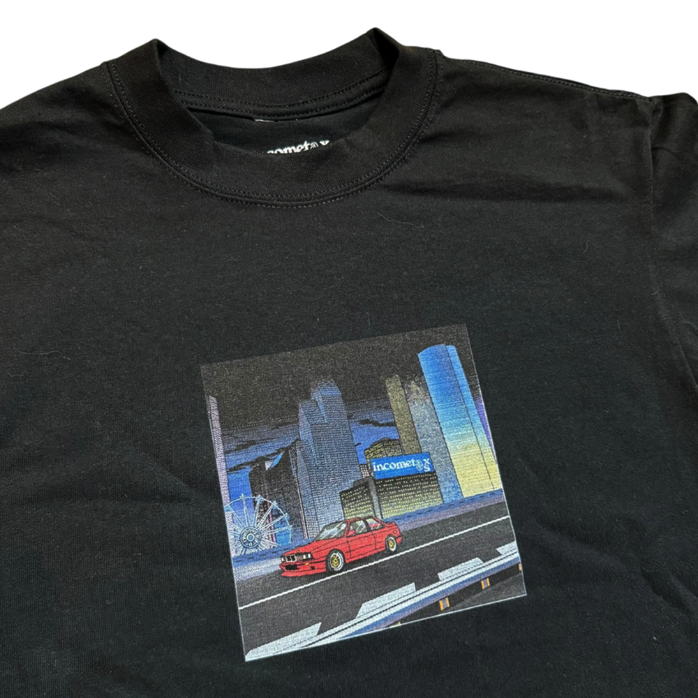 The Beemer Tee Black Income Taxes is a black streetwear t-shirt with a red car graphic in front of a cityscape, Ferris wheel, and blue Incoming sign, crafted from premium USA cotton for comfort and style.