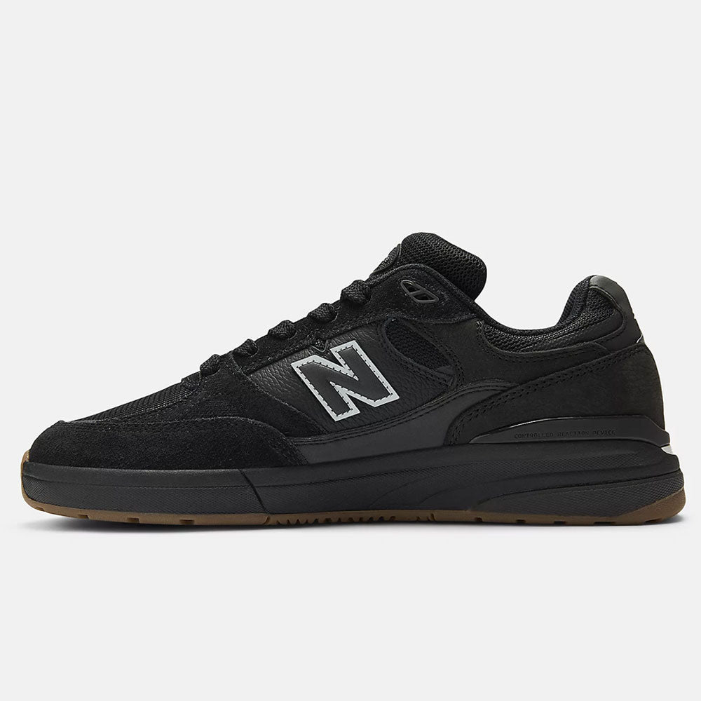 The Black 933 NAP New Balance Numeric Suede Skateboarding Shoes feature a suede and mesh upper, black laces, a white-outlined N logo, and a gum rubber sole—shown in side profile on a plain white background.