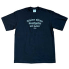 The Black Divine Shine x Southside Still Holdin Max Heavyweight Tee features white gothic text reading "divine shine. southside. still holdin. 1994."—a streetwear piece inspired by Southside Skatepark, shown laid flat on a white background.