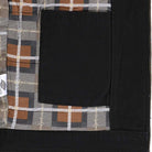 Close-up of the Black Jacket Thrasher Magazine x Dickies Skateboarding A88CE BLK, featuring a black pocket on a brown, gray, black, and white checkered lining, with a small white tag and embroidered front graphic detail visible.