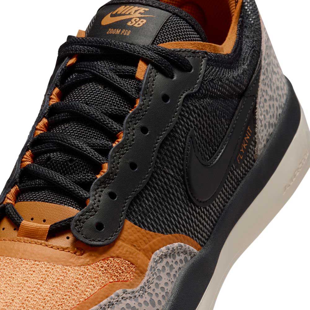 Close-up of a Black Monarch Light Orewood Brown PS8 IR0460001 Nike SB Leather Knit Shoe, showcasing black, orange, and gray tones with textured side panels, black laces, and a prominent Nike swoosh logo. Featuring an advanced leather knit construction for superior breathability and support, this design elevates comfort in skate footwear.
