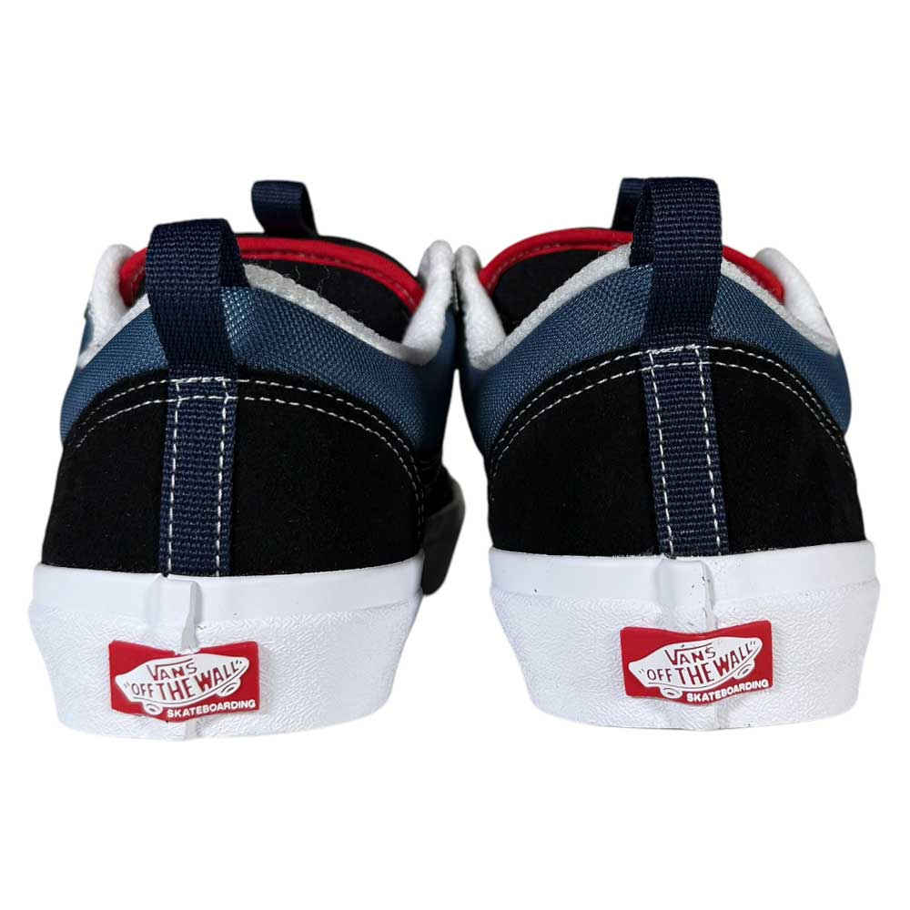 A pair of Black Navy Skate Old Skool 36+ Vans Suede Shoes viewed from the back, showcasing black, navy, and white panels, red interior lining, and white soles.