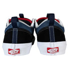 A pair of Black Navy Skate Old Skool 36+ Vans Suede Shoes viewed from the back, showcasing black, navy, and white panels, red interior lining, and white soles.