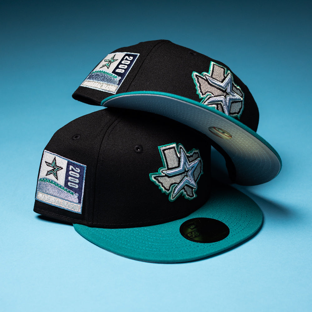 Two Silver Lining Black Teal 2000 Houston Astros New Era Hat 5950 Fitted caps, each featuring a star and Texas logo on the side and a 2000 patch, are displayed on a blue background.