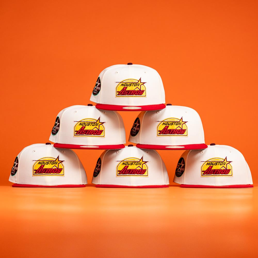 Six Poppa Burger Bo Bundy 35th Houston Astros Bo New Era Hat 5950 Fitted caps are stacked in a pyramid on an orange background, each featuring the bold team logo on the front.