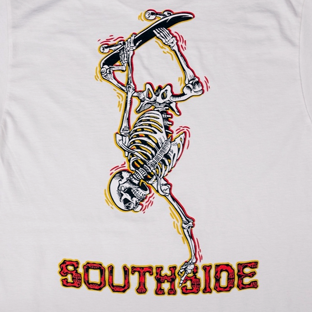 The Bones Pack Ben Raybourn White Southside Skatepark Tee features a skeleton doing a one-handed handstand on a skateboard, with bold red and yellow SOUTHSIDE lettering beneath, inspired by the iconic skatepark.